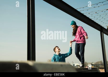 Ragazzo adolescente e una ragazza appendere fuori insieme all'aperto, area industriale, Mannheim, Germania Foto Stock