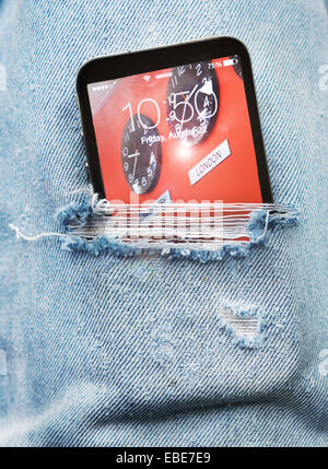 Vista ravvicinata di strappato paio di jeans con un telefono cellulare che fuoriescono, Canada Foto Stock