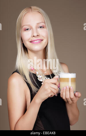 Per piacere. Donna bionda holding tazza di caffè del mattino Foto Stock