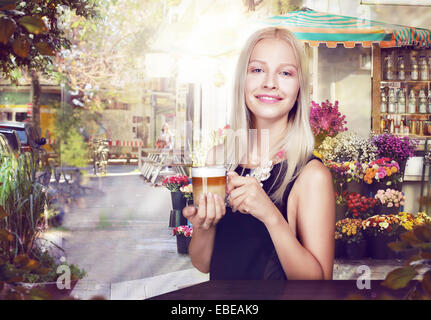 Il ristoro. Donna felice con la tazza di caffè in una Street Cafe Foto Stock