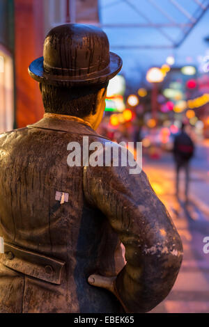 Oliver Hardy replica e gente che passeggia nel centro di Chinatown sulla notte piovosa-Victoria, British Columbia, Canada. Foto Stock