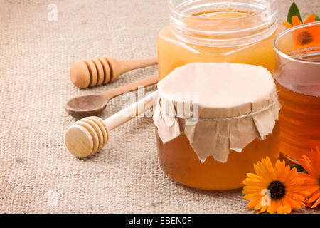 Il miele, fiori e miele nel vaso di vetro sul saccheggio Foto Stock