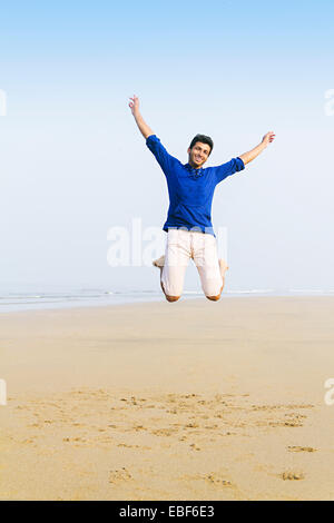 Uomo indiano lato mare Jumping Foto Stock