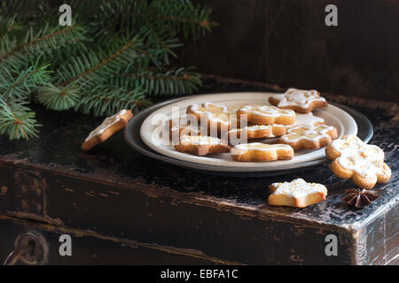 Biscotti di Natale sul vecchio petto nero con albero di Natale Foto Stock