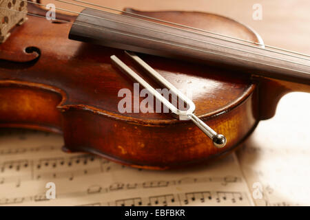 Violino, note musicali e diapason giacente sul violino Foto Stock