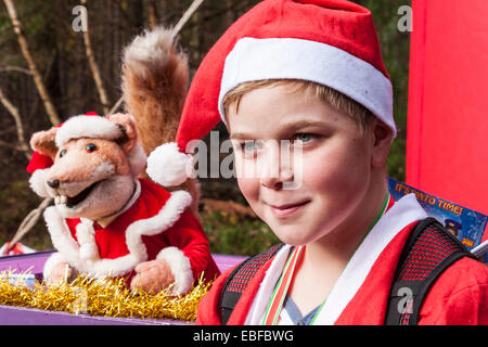 Centinaia di fund-raisers vestiti da Babbo Natale ciclizzato e corse in annuale di 'Santa Dash' per raccogliere fondi per il Tamigi ospizio di carità. Le gare sono state avviate da la spazzola di basilico burattino. Illustrato è uno dei concorrenti è i bambini 2K gara, "Rudolph's Fun Run". Foto Stock