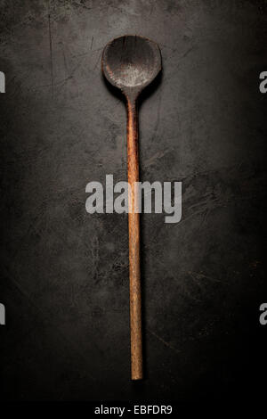 Vecchio cucchiaio di legno su sfondo scuro Foto Stock