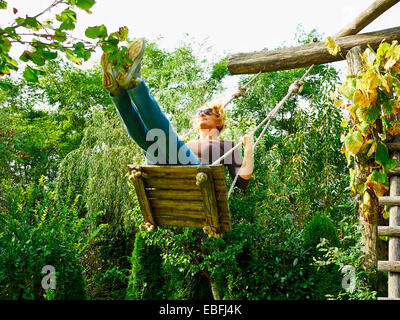 Donna con divertimento su una rotazione sulla bellissima giornata autunnale Foto Stock