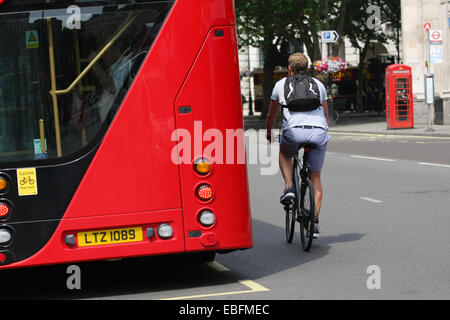 Un ciclista il sorpasso di un rosso fisso London bus Foto Stock