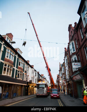 Una gru mobile in street Aberystwyth sollevamento di 1 ton le unità aria condizionata su case e su un ramo del Tesco Express Foto Stock