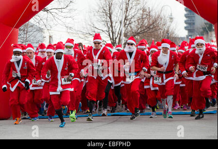 Toronto, Canada. 30 Novembre, 2014. I partecipanti vestiti da Babbo Natale di prendere parte nel 2014 Santa gara di Hamilton, Ontario, Canada, nov. 30, 2014. Circa un migliaio di corridori hanno partecipato all'annuale 5K gara di domenica. Credito: Zou Zheng/Xinhua/Alamy Live News Foto Stock