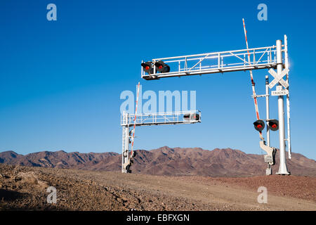 Un occupato attraversamento ferroviario di fronte a delle montagne del deserto Foto Stock