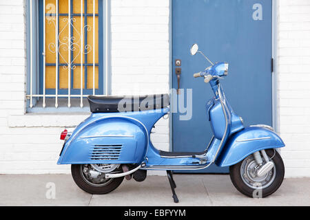 Profilo di luce blu scooter Vespa infront di costruzione Foto Stock