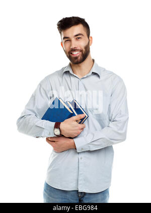 Giovani barbuto uomo sorridente con libri in mani su sfondo bianco Foto Stock