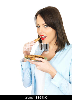 Attraente venti qualcosa di donna di mangiare i biscotti Foto Stock