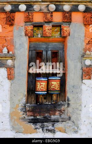 Ruote della preghiera nella parete esterna di un tempio, Jakar, Bumthang distretto, Bhutan Foto Stock