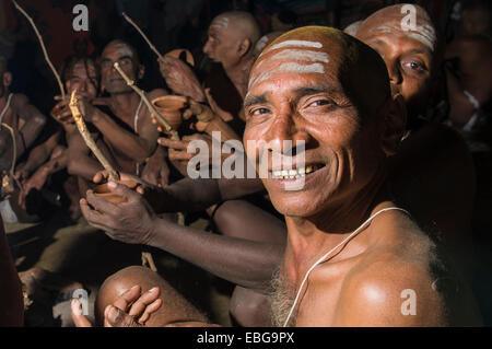 L'uomo unendo l'apertura di nuovi sadhus, durante il Kumbha Mela festival di notte, Allahabad, Uttar Pradesh, India Foto Stock