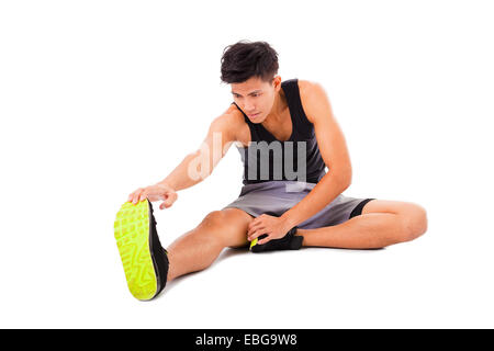 Fitness giovane uomo seduto e fare esercizi di stretching Foto Stock