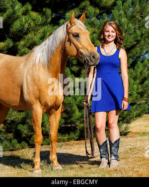 41,857.09455 ragazza abito in piedi accanto al suo cavallo palomino (no) a sella Foto Stock