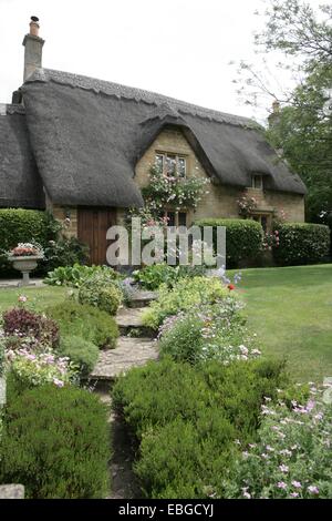 Un grazioso cottage con tetto in paglia in Cotswolds con il suo bel giardino a Chipping Campden Foto Stock