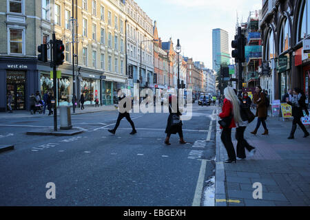 Pedoni che attraversano la strada a Tottenham Court Road Londra Foto Stock