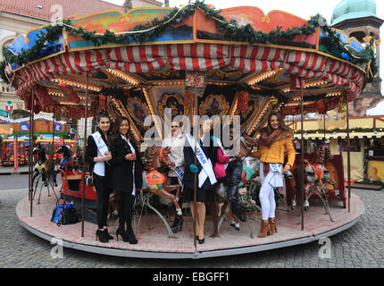 Magdeburg, Germania. 01 dic 2014. Beauty queens in posa su una giostra al mercatino di Natale di Magdeburgo, Germania, 01 dicembre 2014. 70 giovani donne qualificati per la finale mondiale il 04 dicembre 2014 nel terzo più grande corteo di bellezza. Foto: Jens WOLF/dpa/Alamy Live News Foto Stock