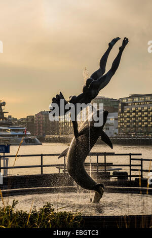 Ragazza con un delfino statua fiume Tamigi - LONDRA Foto Stock