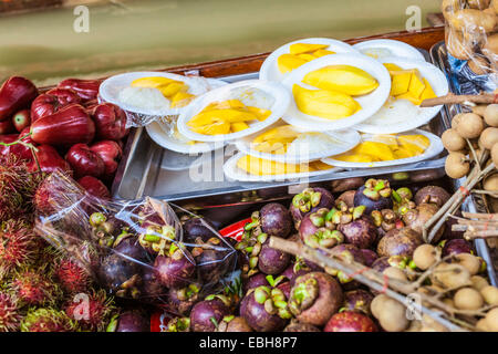 Venditori ambulanti vendono frutta e verdura nel tradizionale mercato galleggiante di Damnoen Saduak vicino a Bangkok, in Thailandia Foto Stock