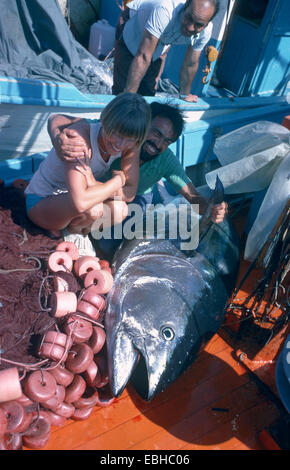 Tonni, tonno rosso, blu-alettato di tonno, il tonno rosso (Thunnus thynnus), giacente sul ponte, con felice pescatori. Foto Stock