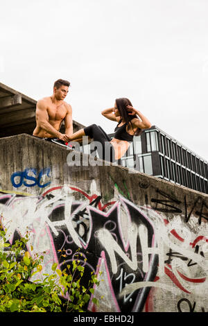 Personal trainer facendo outdoor training in luogo urbano, Monaco di Baviera, Germania Foto Stock