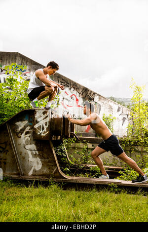 Personal trainer facendo outdoor training in luogo urbano, Monaco di Baviera, Germania Foto Stock