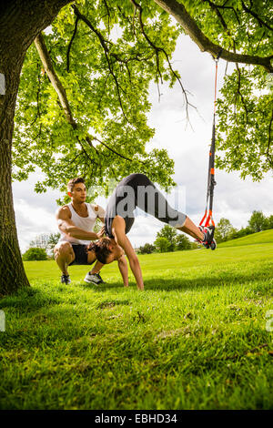 Personal trainer facendo outdoor training in luogo urbano, Monaco di Baviera, Germania Foto Stock