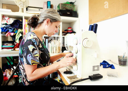 Designer che lavora alla macchina da cucire in studio Foto Stock