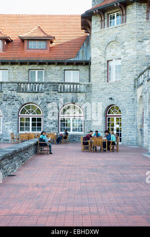 Gli studenti seduti sul patio esterno palazzo universitario Foto Stock