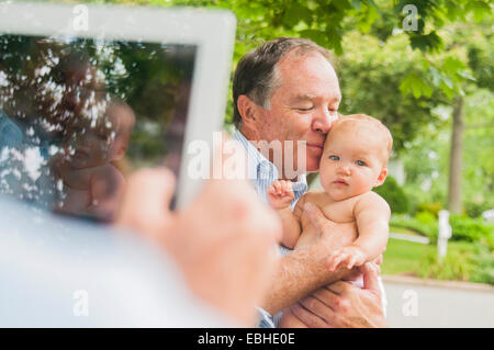 Sulla spalla ritratto del nonno e nipote del bambino prese sulla tavoletta digitale Foto Stock