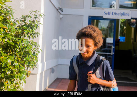 Schoolgirl camminando nella scuola Foto Stock