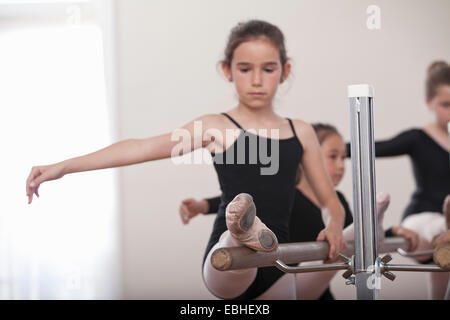 Giovane ballerina di esercitarsi in barre nella scuola di danza Foto Stock