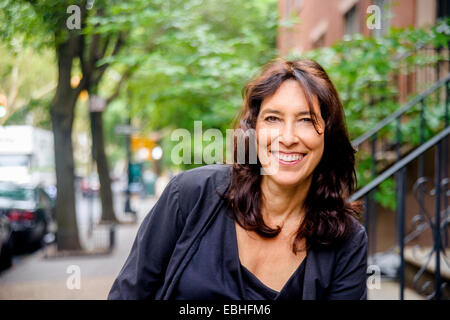 Ritratto di sorridere donna matura sulla strada di città Foto Stock