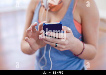 Ritagliato shot della ragazza adolescente utilizza lo smartphone touchscreen nella scuola di danza Foto Stock