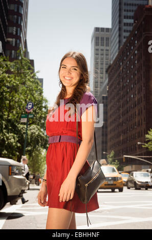 Giovane donna indossa abito rosso, Manhattan, New York, Stati Uniti d'America Foto Stock
