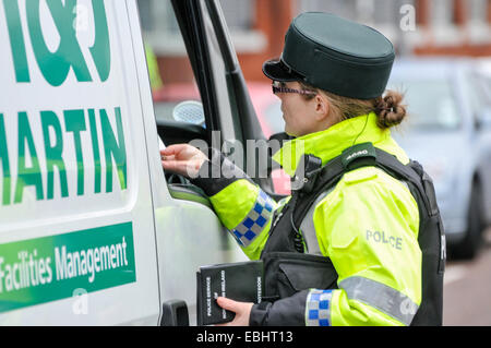 Belfast, Irlanda del Nord. 01 dic 2014 - PSNI officer controlla una patente di guida a un veicolo temporaneo checkpoint. Si tratta dopo ACC Kerr avverte che i dissidenti repubblicani sono intenti a lanciare un bombardamento o uccidere la campagna nel periodo di Natale. Credito: Stephen Barnes/Alamy Live News Foto Stock