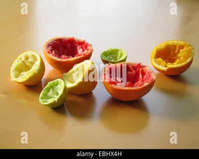 Gli agrumi trasformati in succo. Pompelmo, limone, arancio, calce sulla tabella marrone Foto Stock