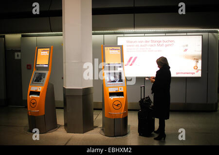 Berlino, Germania. 1 dicembre, 2014. Un passeggero si erge nei pressi di Lufthansa di macchine automatiche in aeroporto Tegel di Berlino, Germania, il 1 dicembre, 2014. Compagnia aerea tedesca Lufthansa ha detto il lunedì che aveva annullato quasi la metà dei suoi voli di linea il lunedì e martedì a causa di uno sciopero dai suoi piloti. © Zhang ventola/Xinhua/Alamy Live News Foto Stock