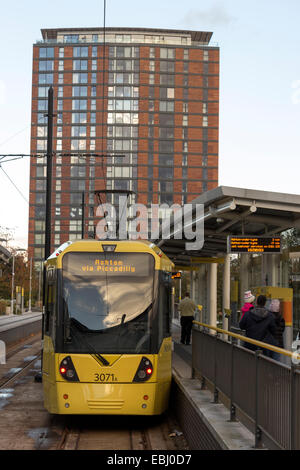 Piattaforma, Media City Metrolink Station con il tram, moderno blocco di appartamenti in background, Salford Quays, Manchester, Regno Unito Foto Stock