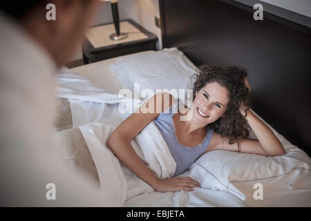 Giovane donna giaceva sul letto, angolo alto Foto Stock