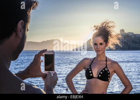 L'uomo fotografare la giovane donna in vacanza Foto Stock