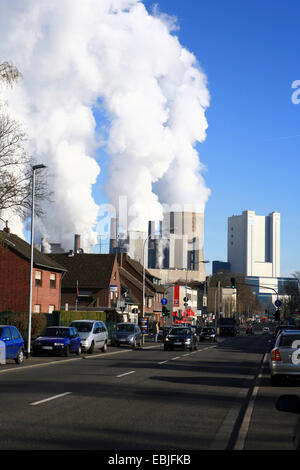 Vista attraverso una strada di città con incalza e marrone fumo di centrali elettriche a carbone Niederaussem, in Germania, in Renania settentrionale-Vestfalia, Niederaussem, Bergheim Foto Stock