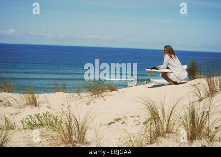 Donna con la tavola da surf sulla spiaggia Lacanau, Francia Foto Stock