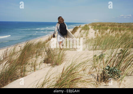 Donna con la tavola da surf sulla spiaggia Lacanau, Francia Foto Stock