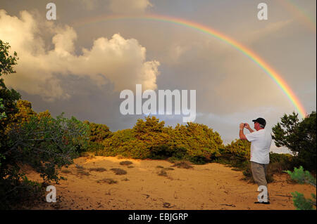 Fotografo di natura dipinge l'arcobaleno oltre le dune a ovest Peloponneso, Grecia, Peloponneso, Messenia Foto Stock